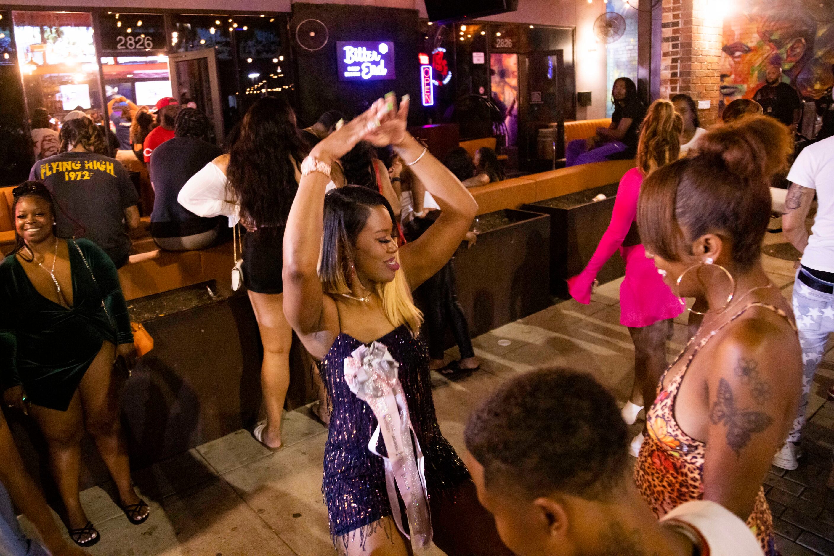 Brittany Toussaint, who is celebrating her birthday, dances outside of Bitter End in the...