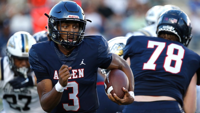 Allen High School quarterback Mike Hawkins (3) runs behind the block from Allen High School...