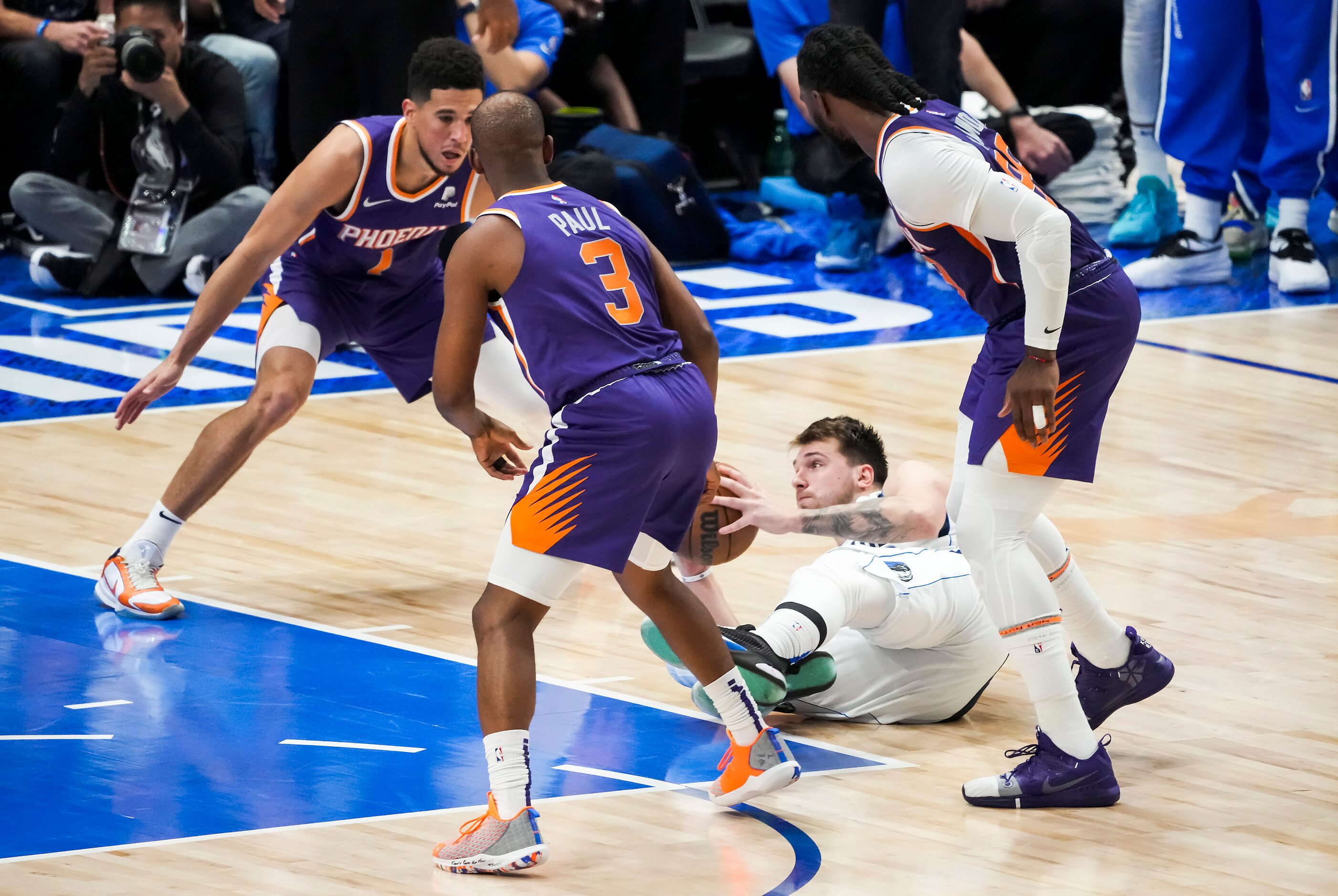 Dallas Mavericks guard Luka Doncic (77) falls to the floor chasing a ball between Phoenix...