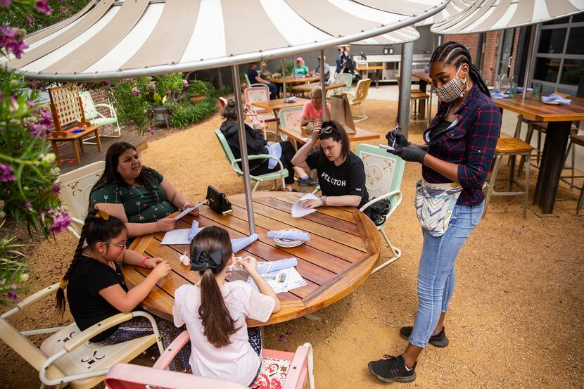 Server Daniela Umunnakwe (right) takes diner's orders at the Ida Claire patio on May 15,...