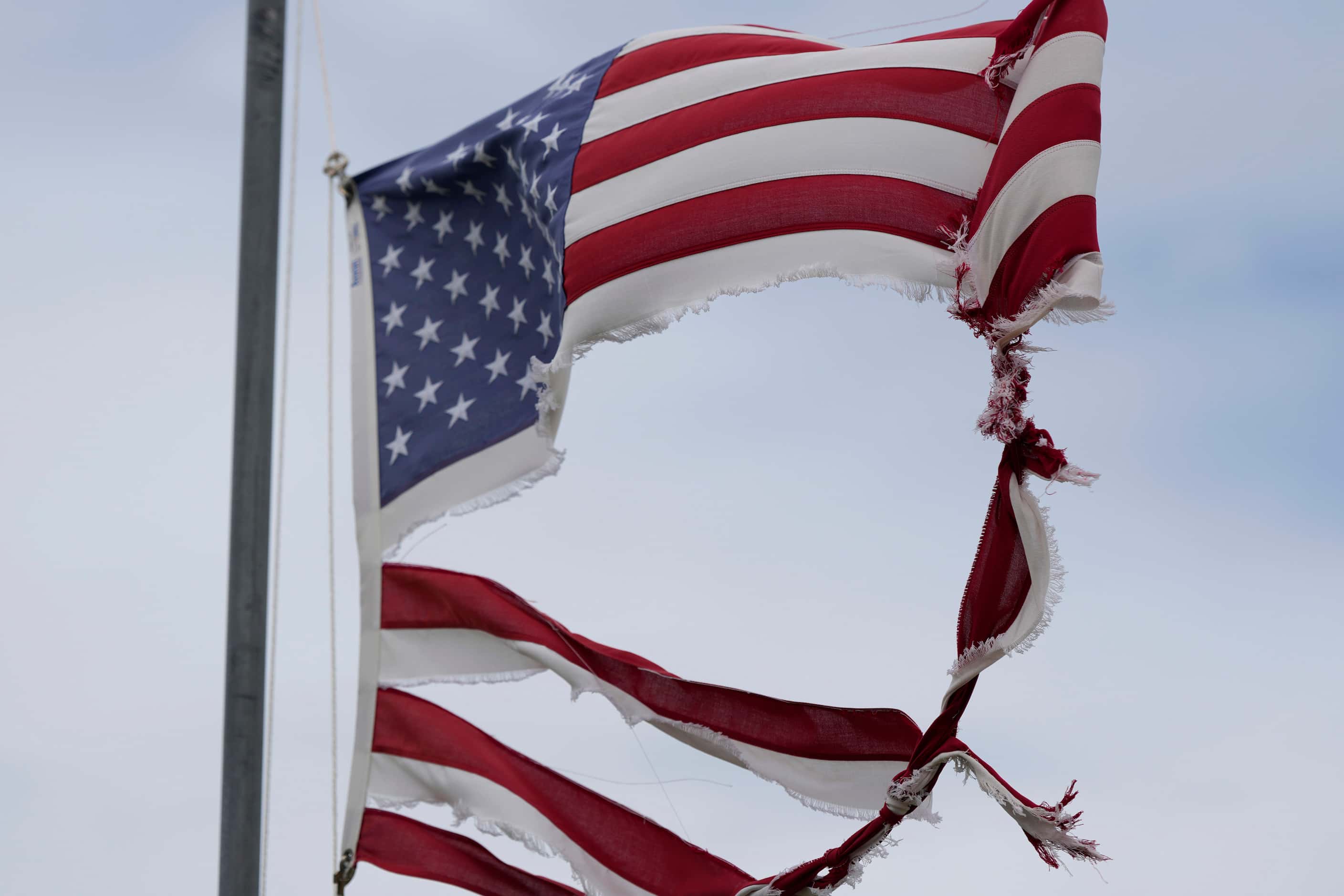 A tattered flag tips in the wind after Beryl moved through the area, Monday, July 8, 2024,...