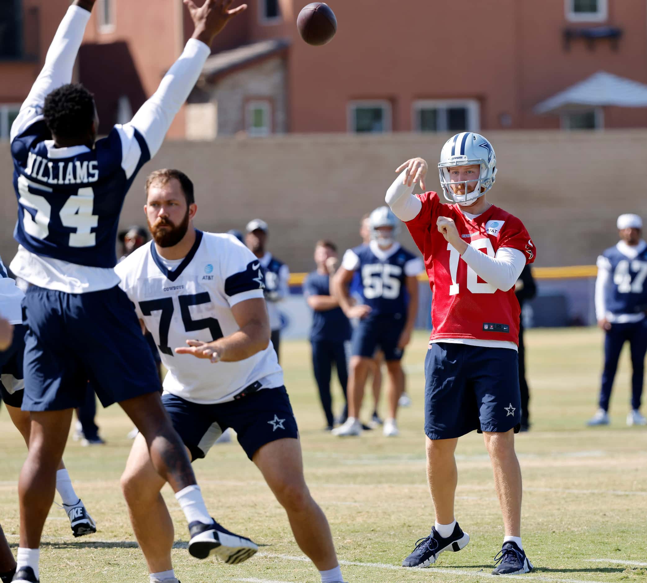 Dallas Cowboys quarterback Cooper Rush (10) tosses a soft pass during a mock game at...