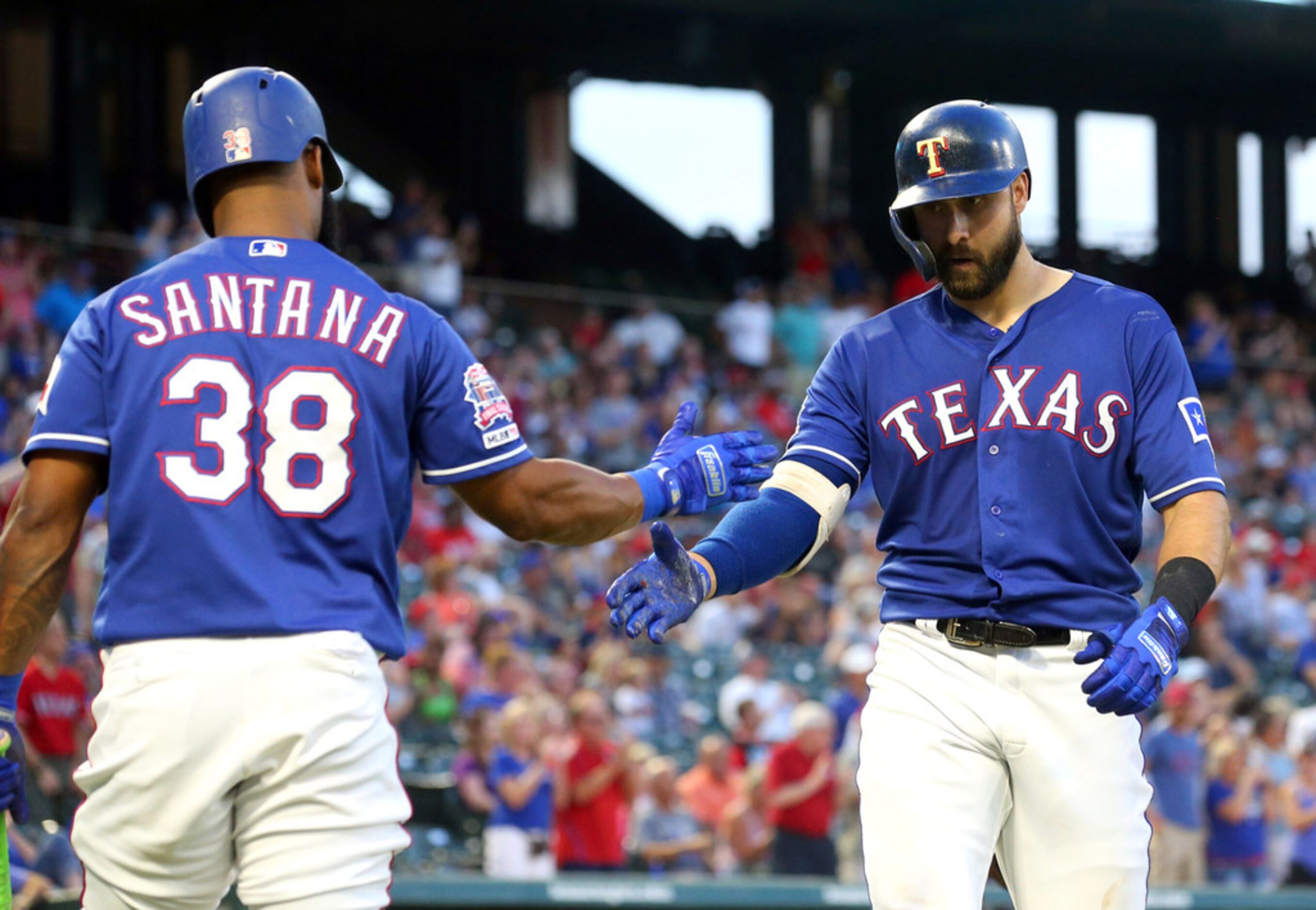 Texas Rangers' Danny Santana (38) celebrates the solo home run by Joey Gallo (13) during the...