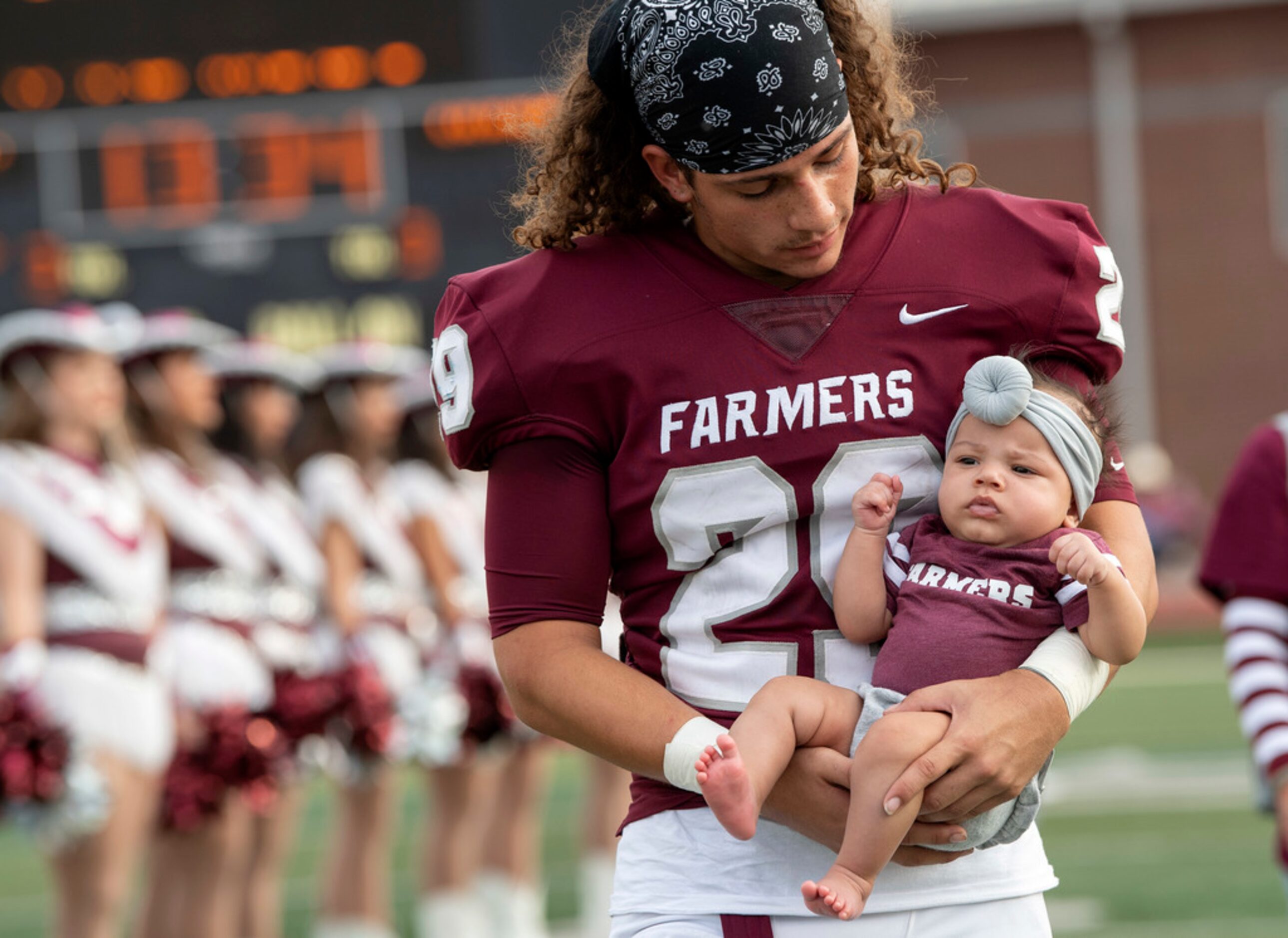 Lewisville senior Keelan Finney (29) cradles his 4-month-old niece Aariyah Bradley during...