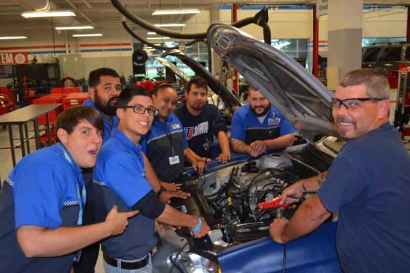 
Jeremy Krenz (right), 38, of Grand Prairie, works on a car with fellow students at the...