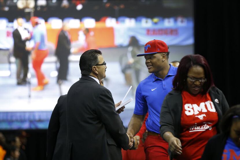 Kimball defensive lineman Demerick Gary, who signed with SMU receives a congratulatory hand...