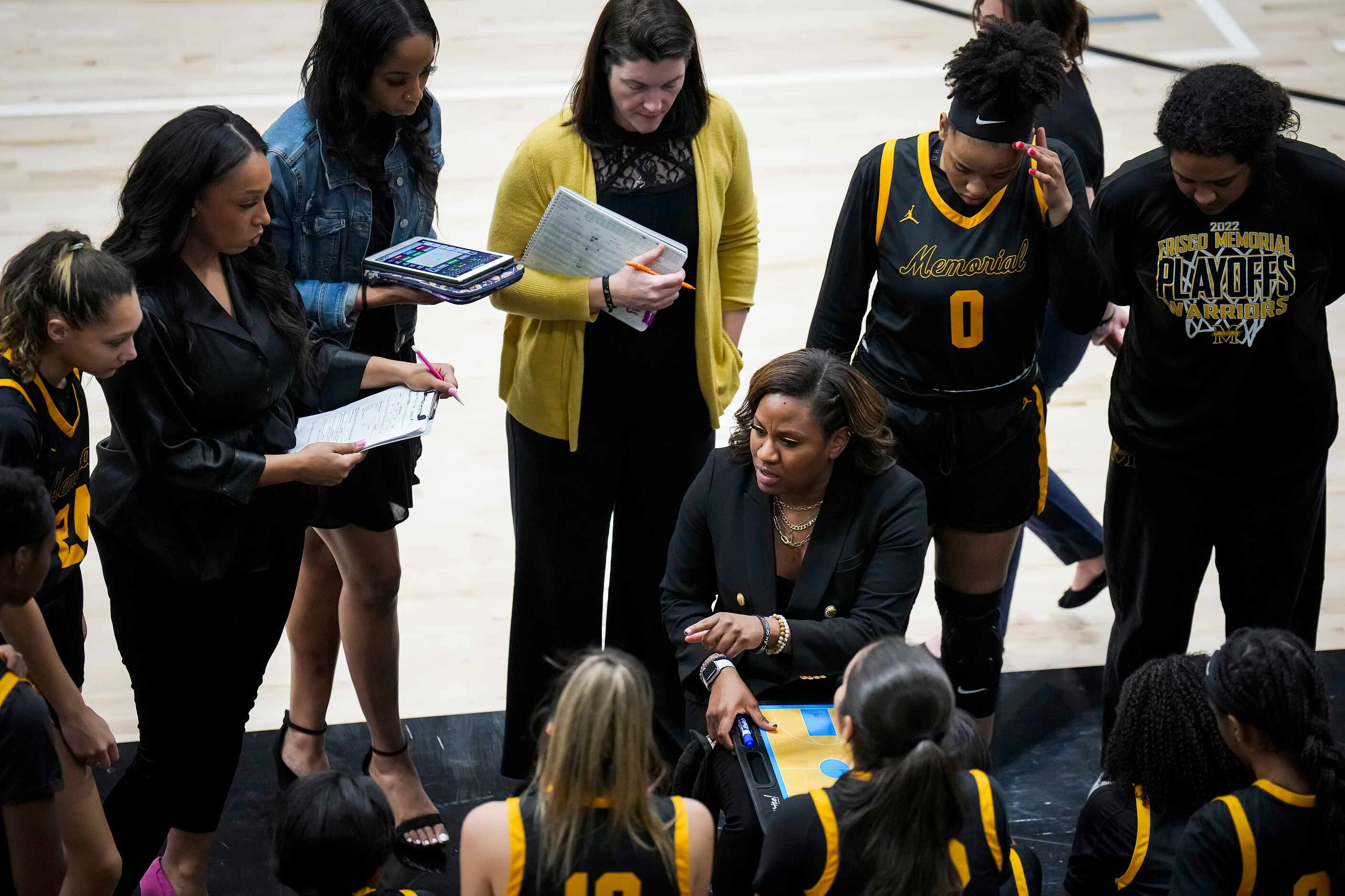 Frisco Memorial players gather around head coach Rochelle Vaughn during a timeout in a Class...