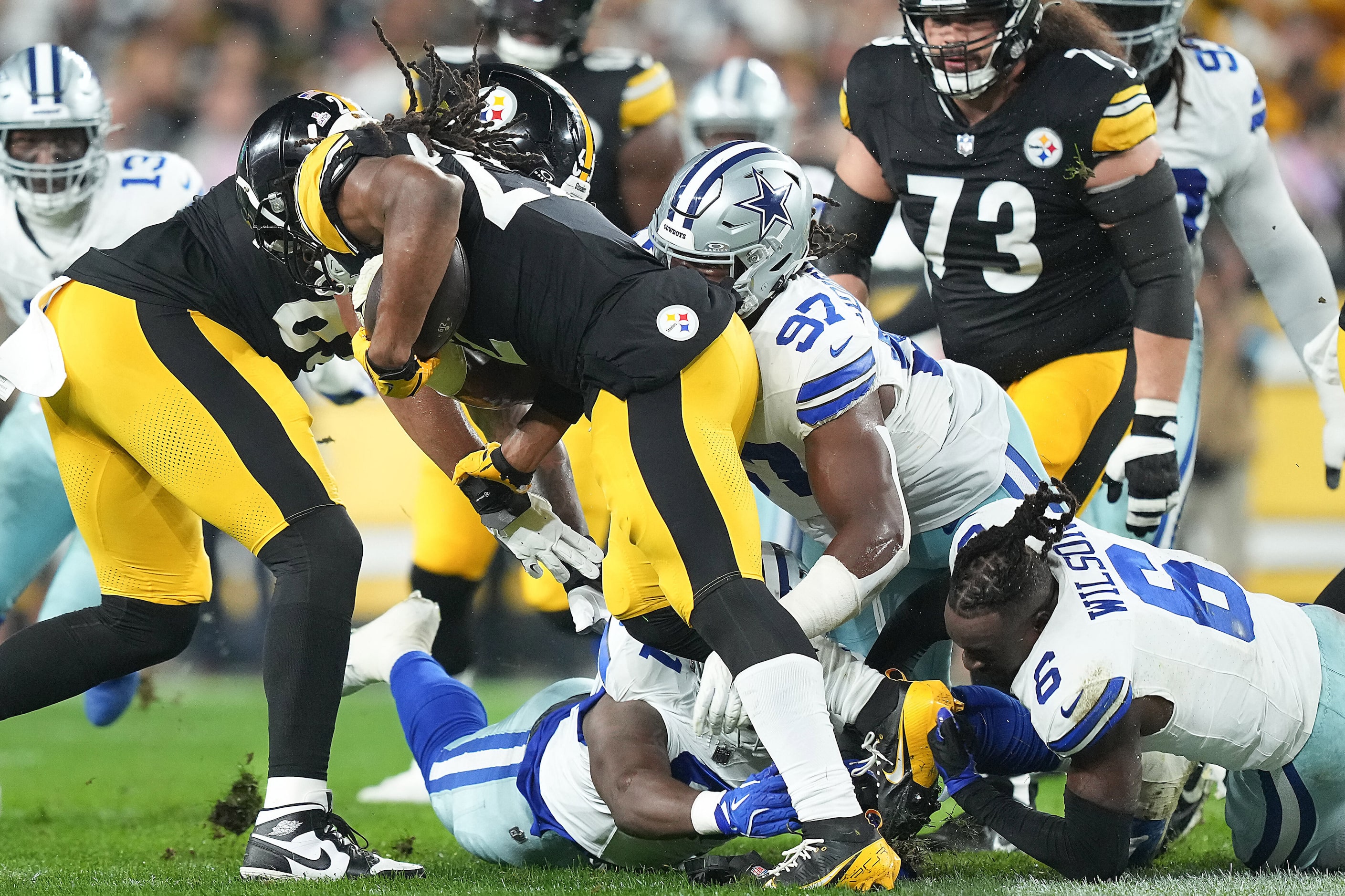 Pittsburgh Steelers running back Najee Harris (22) is brought down byDallas Cowboys...