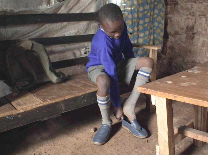 
A Kenyan boy dons shoes made from old Southwest Airlines airplane seats. 
