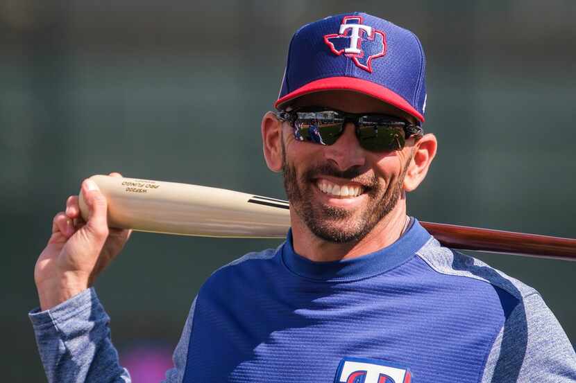 Texas Rangers manager Chris Woodward smiles while watching batting practice during the first...