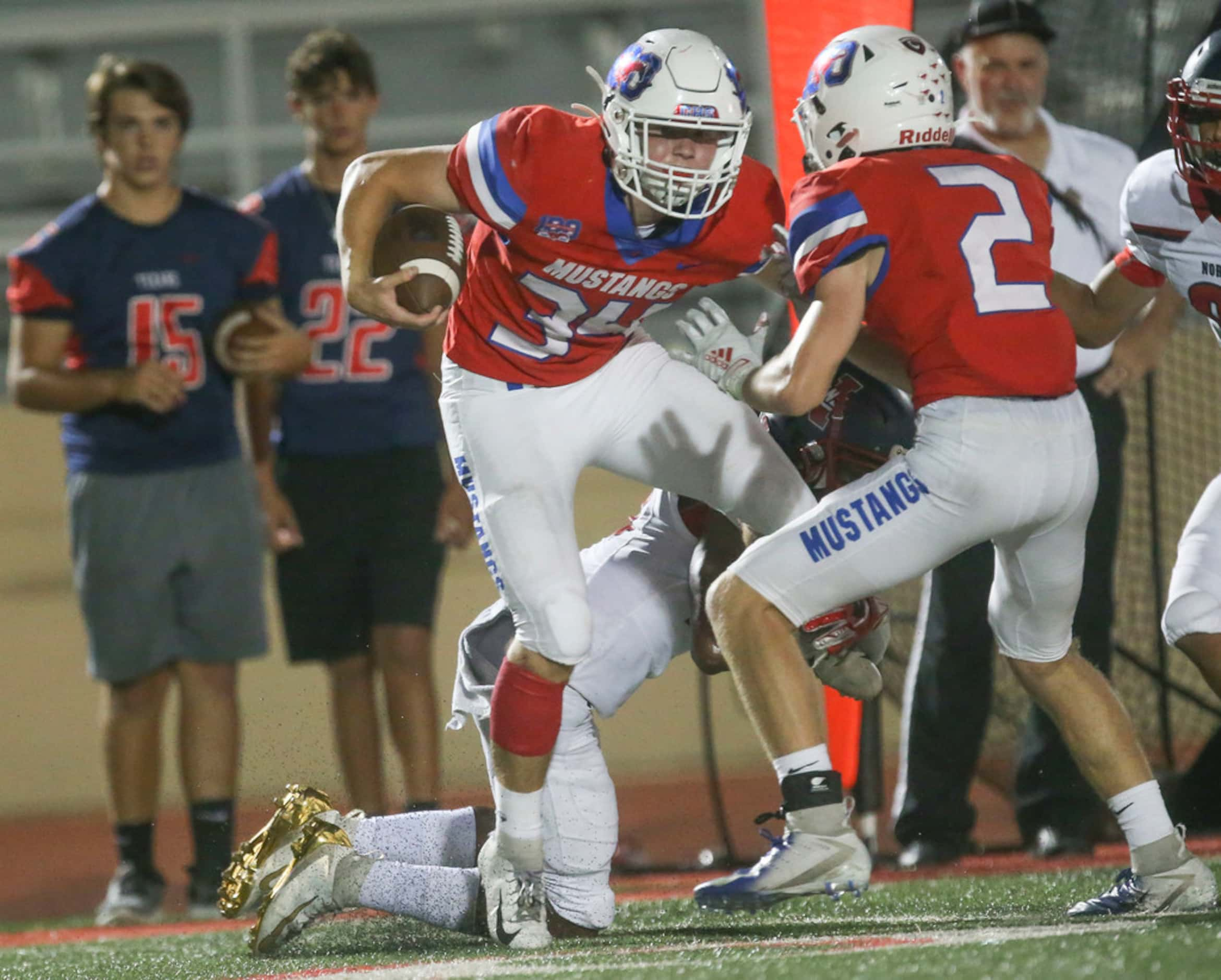 Grapevine running back Eliot Hanson (34) gets wrapped up by Northwest's Jordan Dunn (18)...