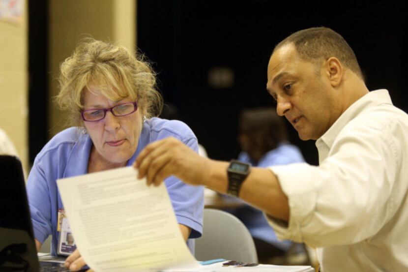 Affordable Care Act navigator Andrew Moura helps Debbie Sands sign up for coverage in...