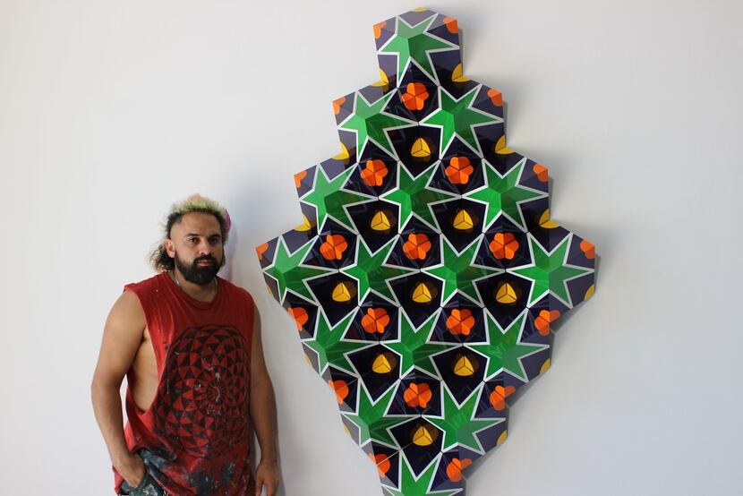 Dallas artist Ricardo Paniagua poses next to one of his recent works.