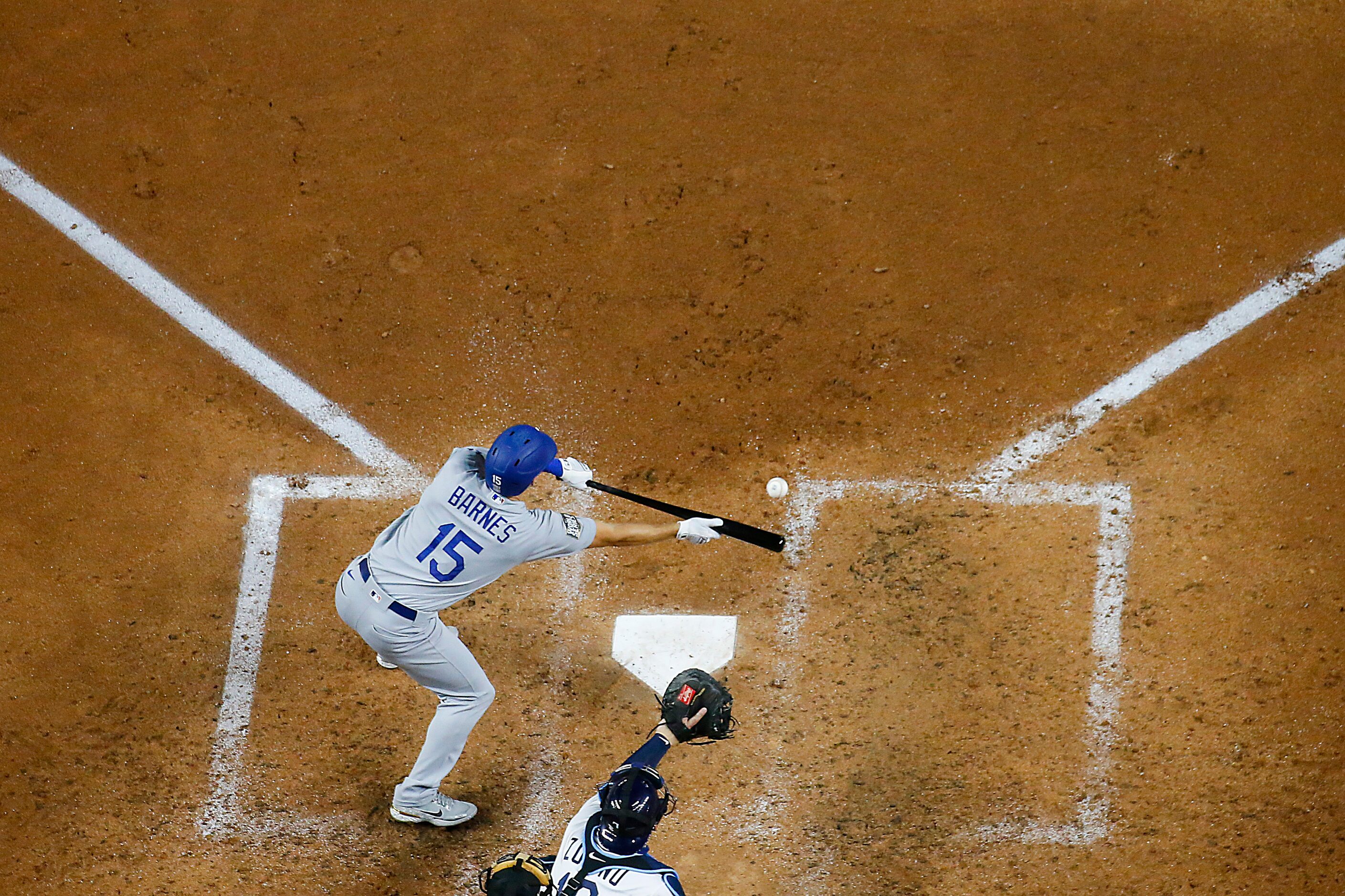 Los Angeles Dodgers catcher Austin Barnes puts down a sacrifice bunt to score center fielder...