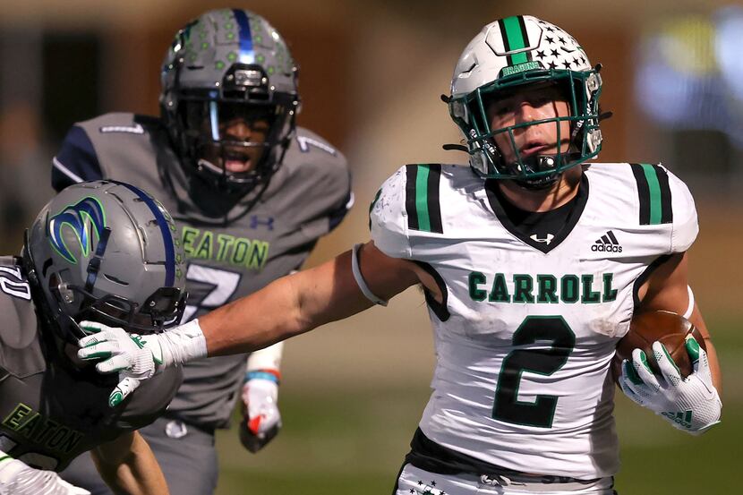 Southlake Carroll running back Owen Allen (2) gives a stiff arm to Eaton safety Aric Wood...