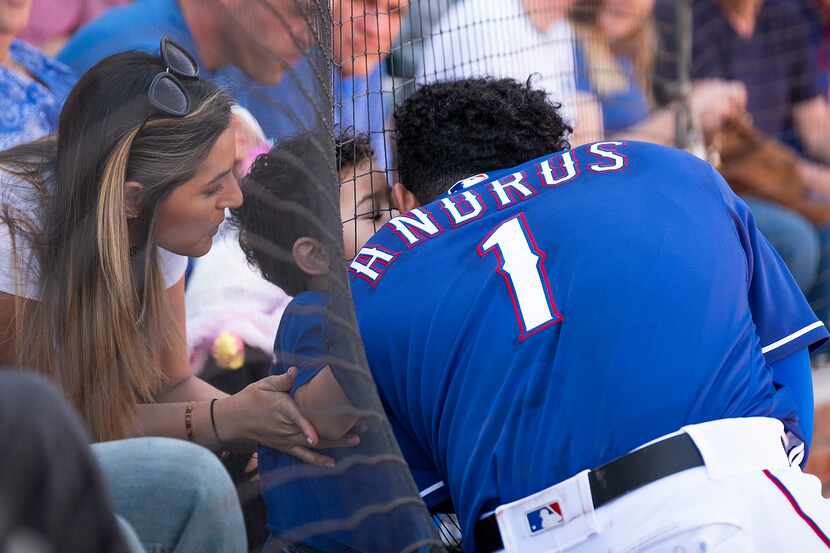 Texas Rangers shortstop Elvis Andrus gets a kiss from his son as he waits on deck during the...