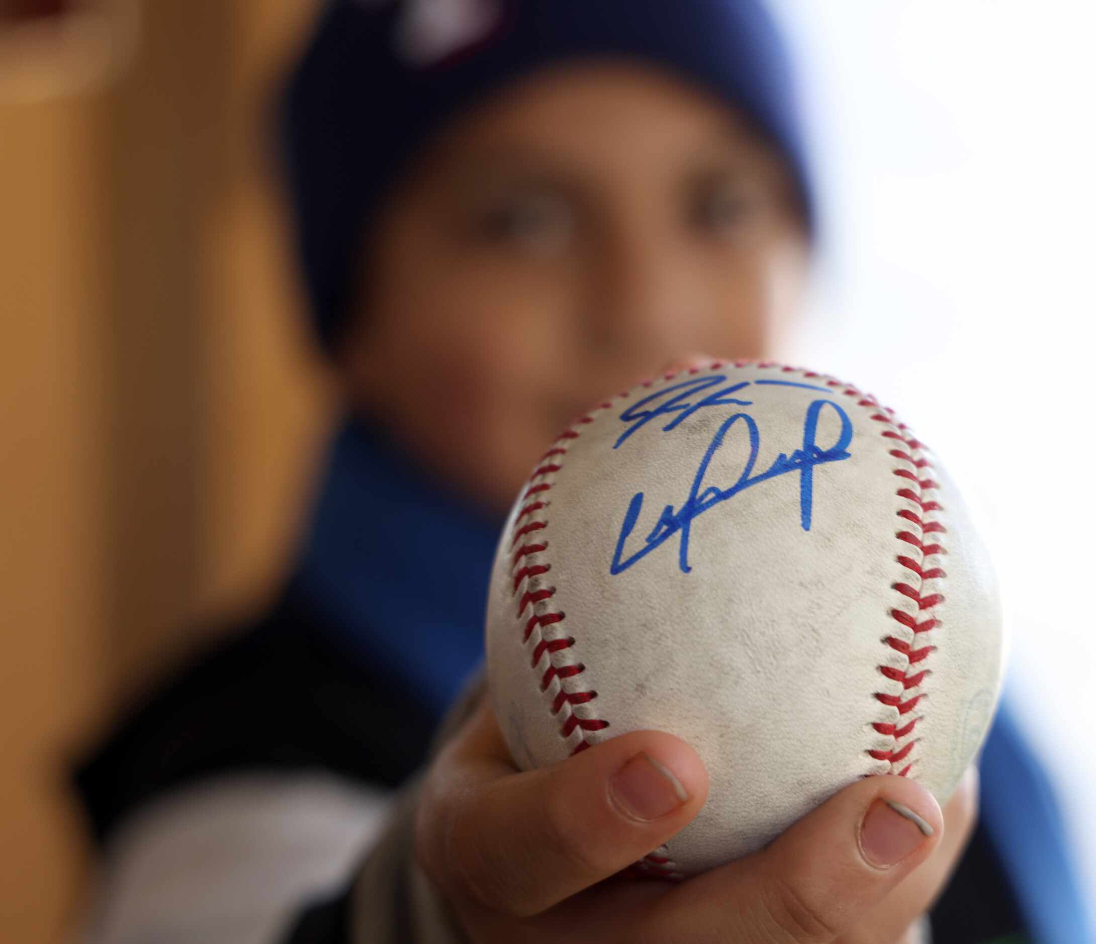 Texas Rangers fan Pablo Sosa, 9, poses after getting autographs from players on his souvenir...