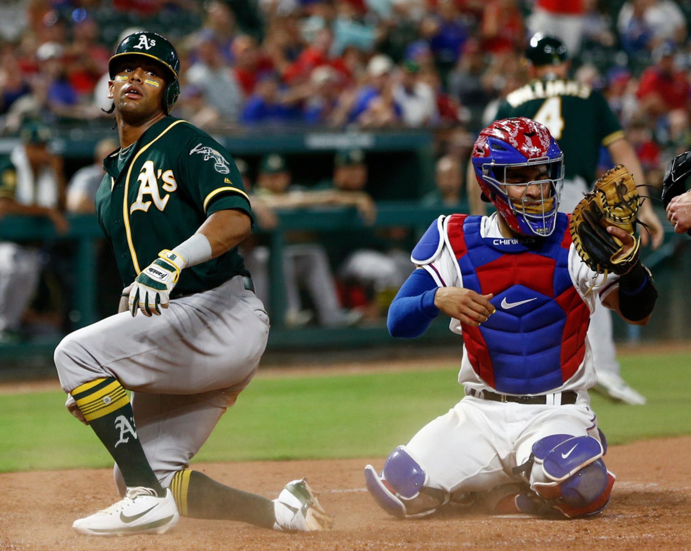 Oakland Athletics' Khris Davis, left, reacts after getting tagged out at home by Texas...