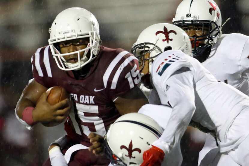 Red Oak running back CJ Palmer (15) has his eye on scoring but is stopped by Dallas Kimball...