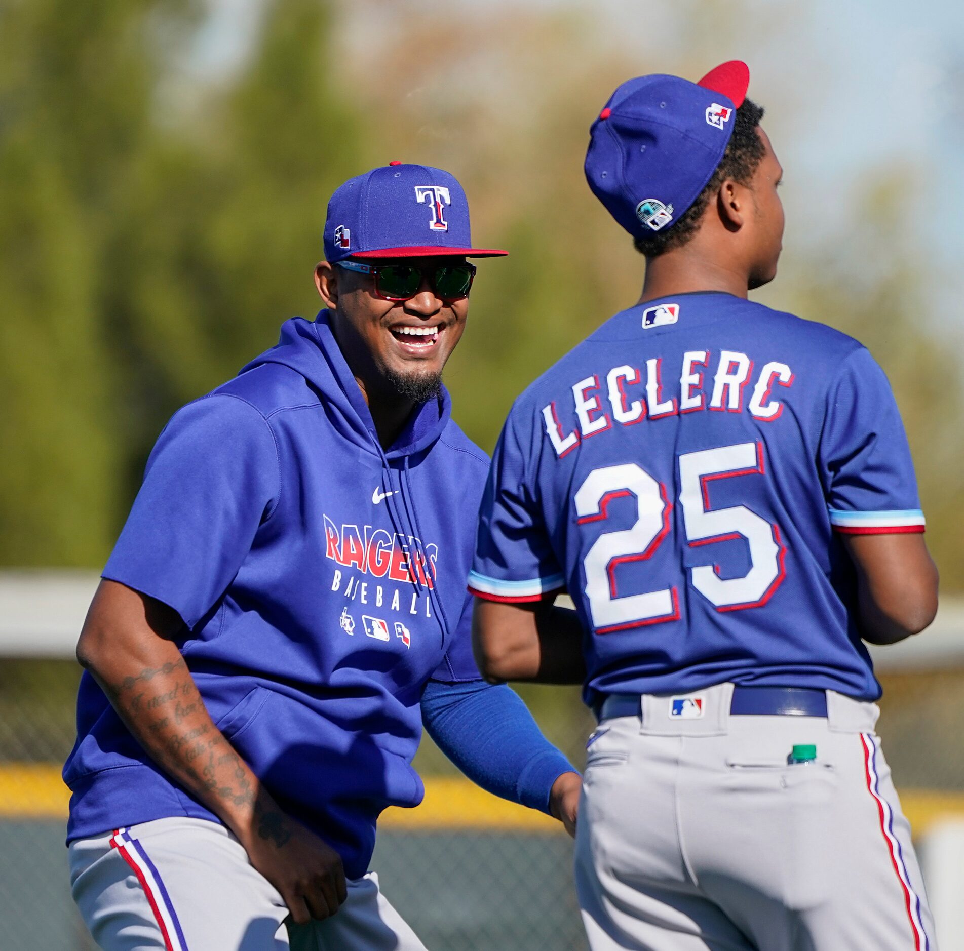 Texas Rangers pitcher Edinson Volquez laughs with Jose Leclerc during a spring training...