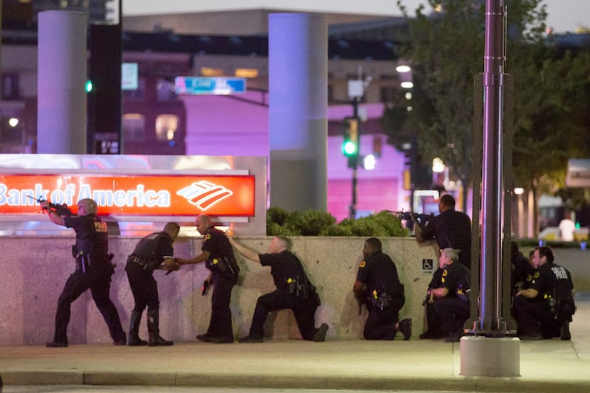 Dallas police took up position along a wall at the corner of Lamar and Main streets after...