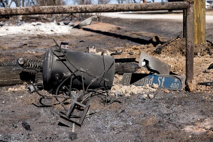 A fallen street sign rests against other debris.