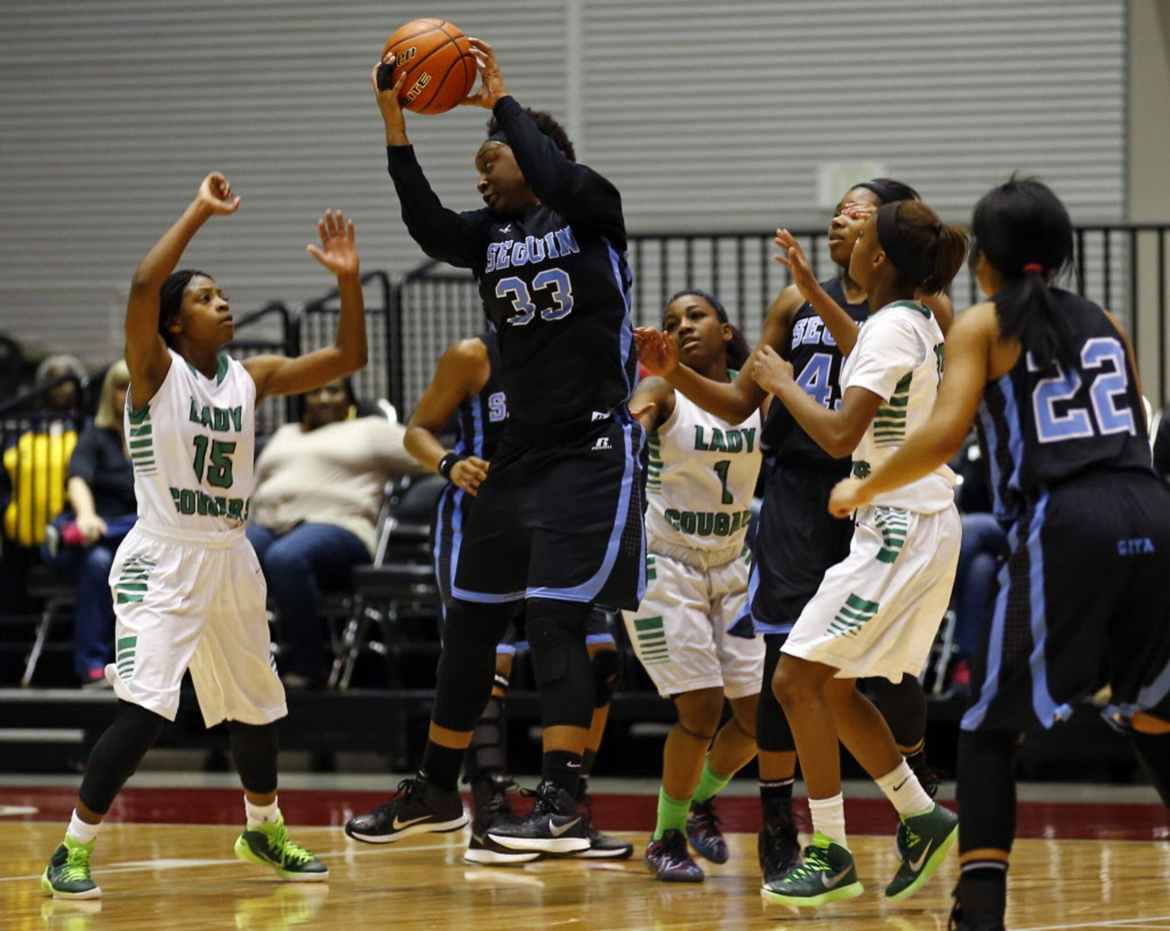 Arlington Seguin's Tajshia Moore (33) grabs a rebound over Bryan Adams' DeBrashia Baty (15)...