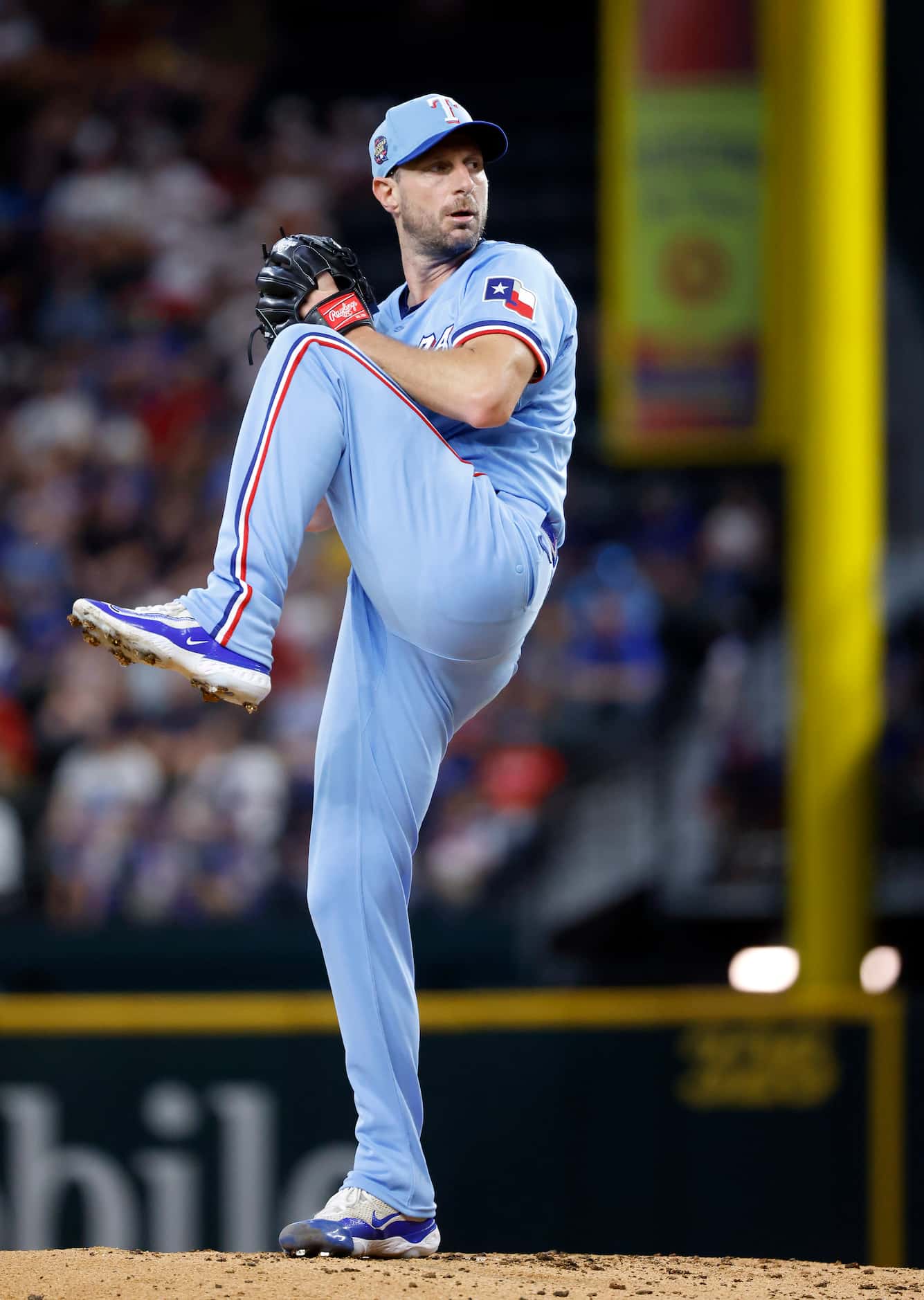 Texas Rangers starting pitcher Max Scherzer does a high kick before hurling a pitch to the...