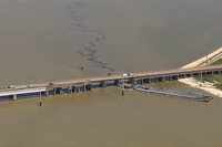 Oil spills into the surrounding waters after a barge hit a bridge near Galveston, Texas, on...