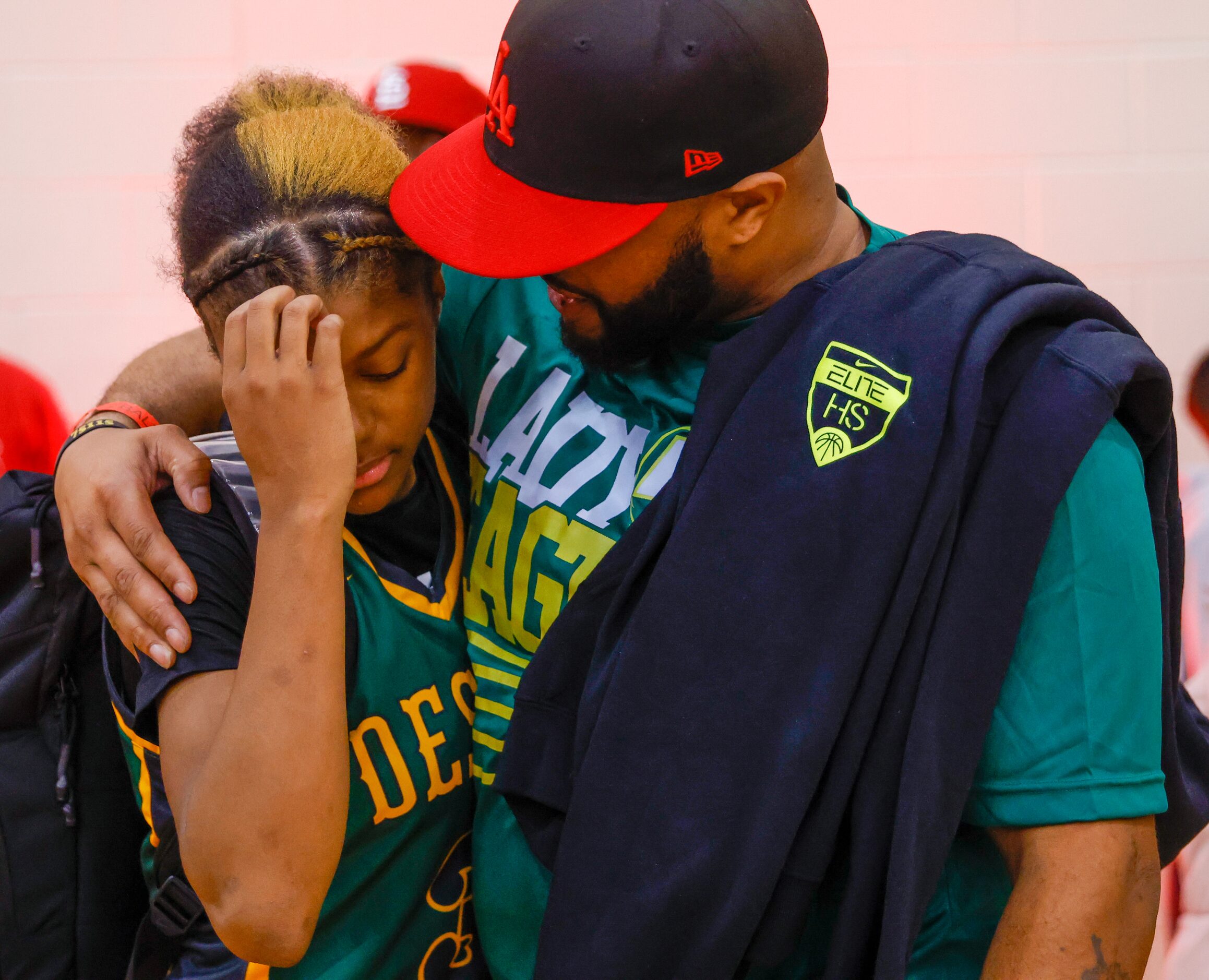 DeSoto point guard Rieyan DeSouze (3, left) receives a hug after DeSoto’s loss against...