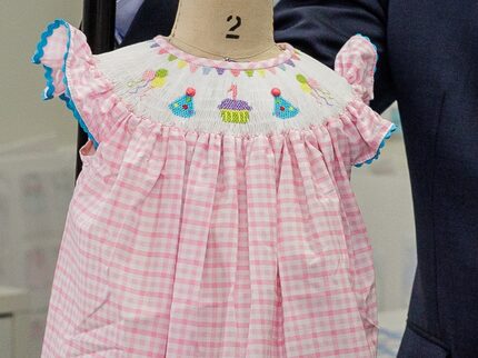 This pink gingham dress has smocking and embroidery across the bodice. 