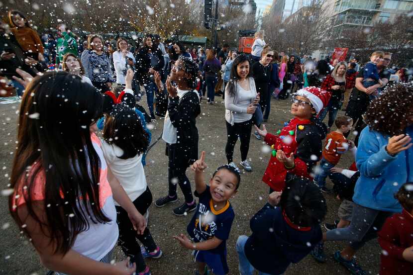 Kids play in fake snow during the 2018 tree lighting celebration at Klyde Warren Park. This...