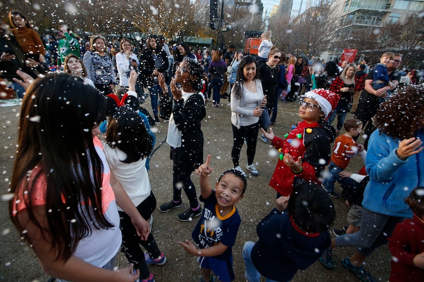 Kids play in fake snow during the 2018 tree lighting celebration at Klyde Warren Park. This...