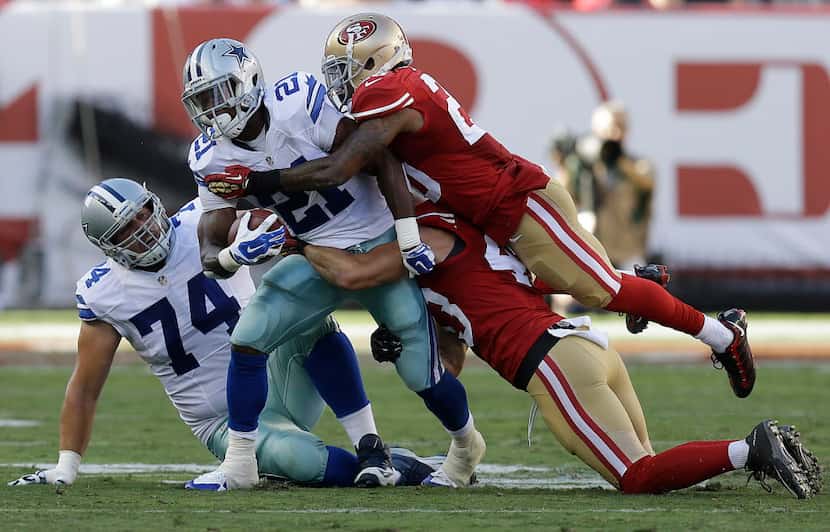 Dallas Cowboys running back Joseph Randle (21) is tackled by San Francisco 49ers cornerback...