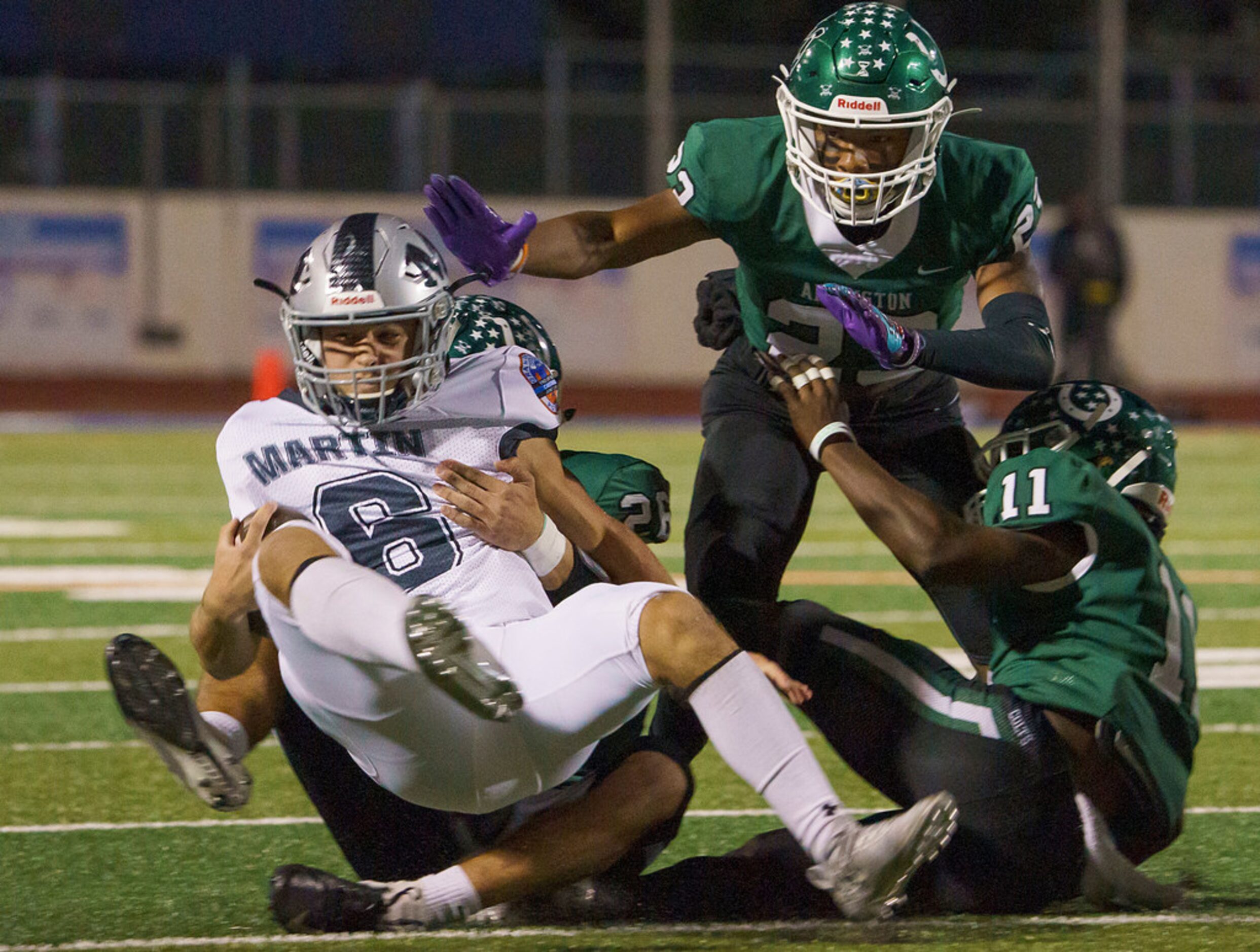 Arlington Martin quarterback Zach Mundell (6) is brought down by Arlington linebacker ...