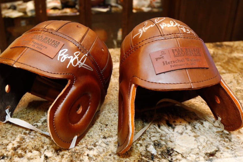 Leather football helmets signed by Barry Sanders, left, and Herschel Walker are part of SMU...