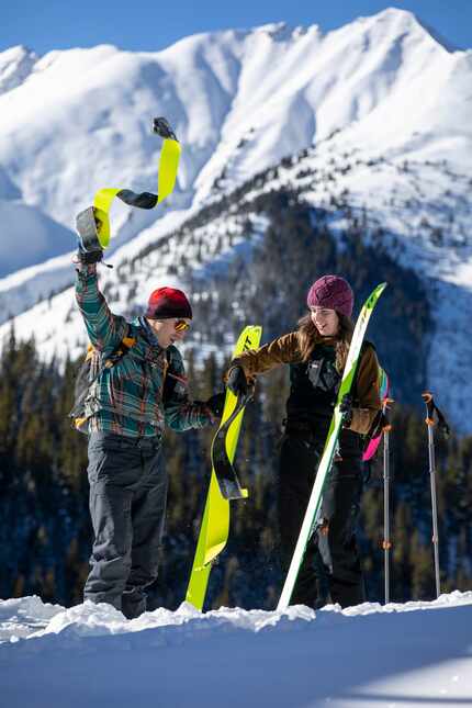 Skiers remove their climbing skins. The adhesive, carpetlike attachments affix to the...