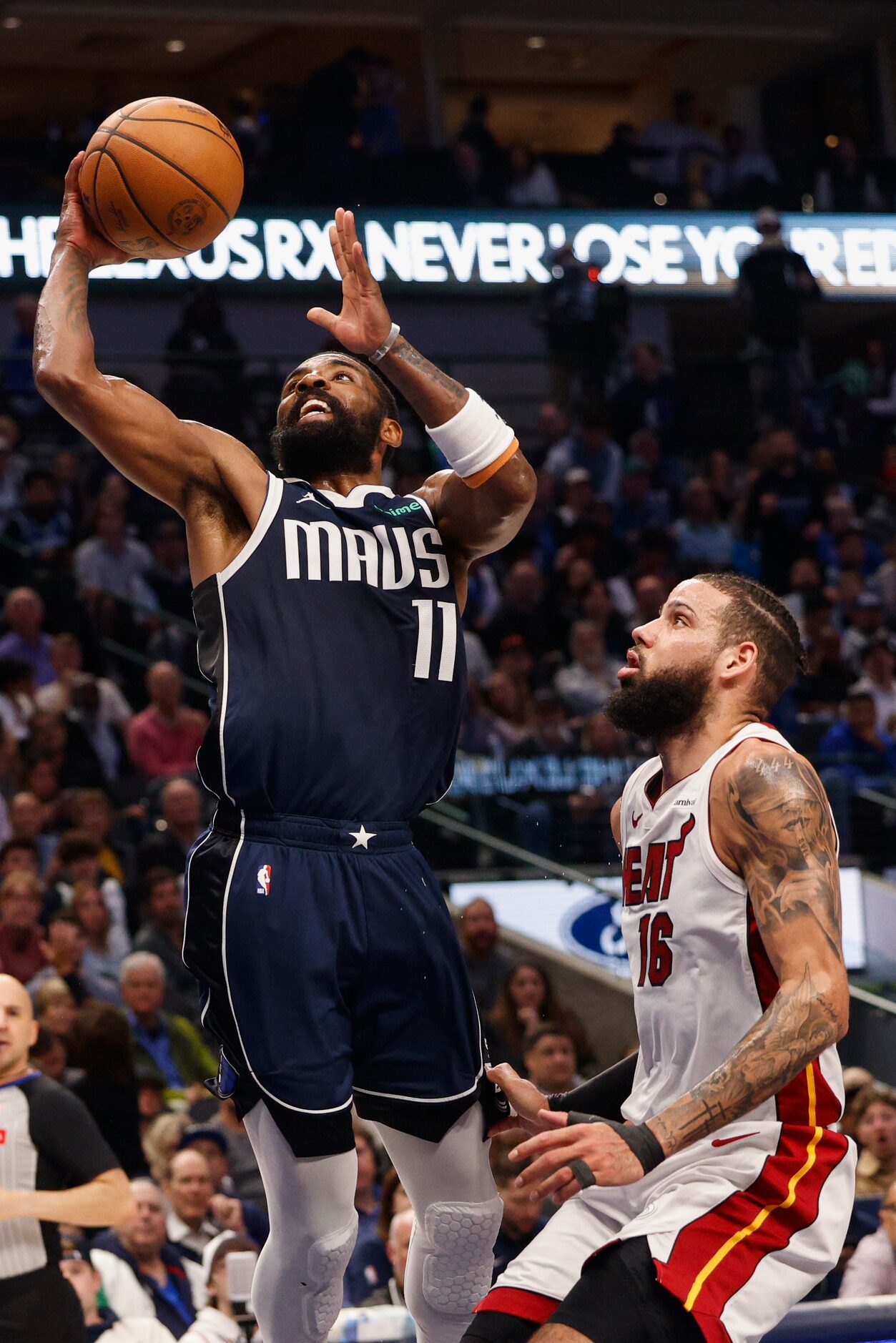 Dallas Mavericks guard Kyrie Irving (11) lays the ball up against a defending Miami Heat...