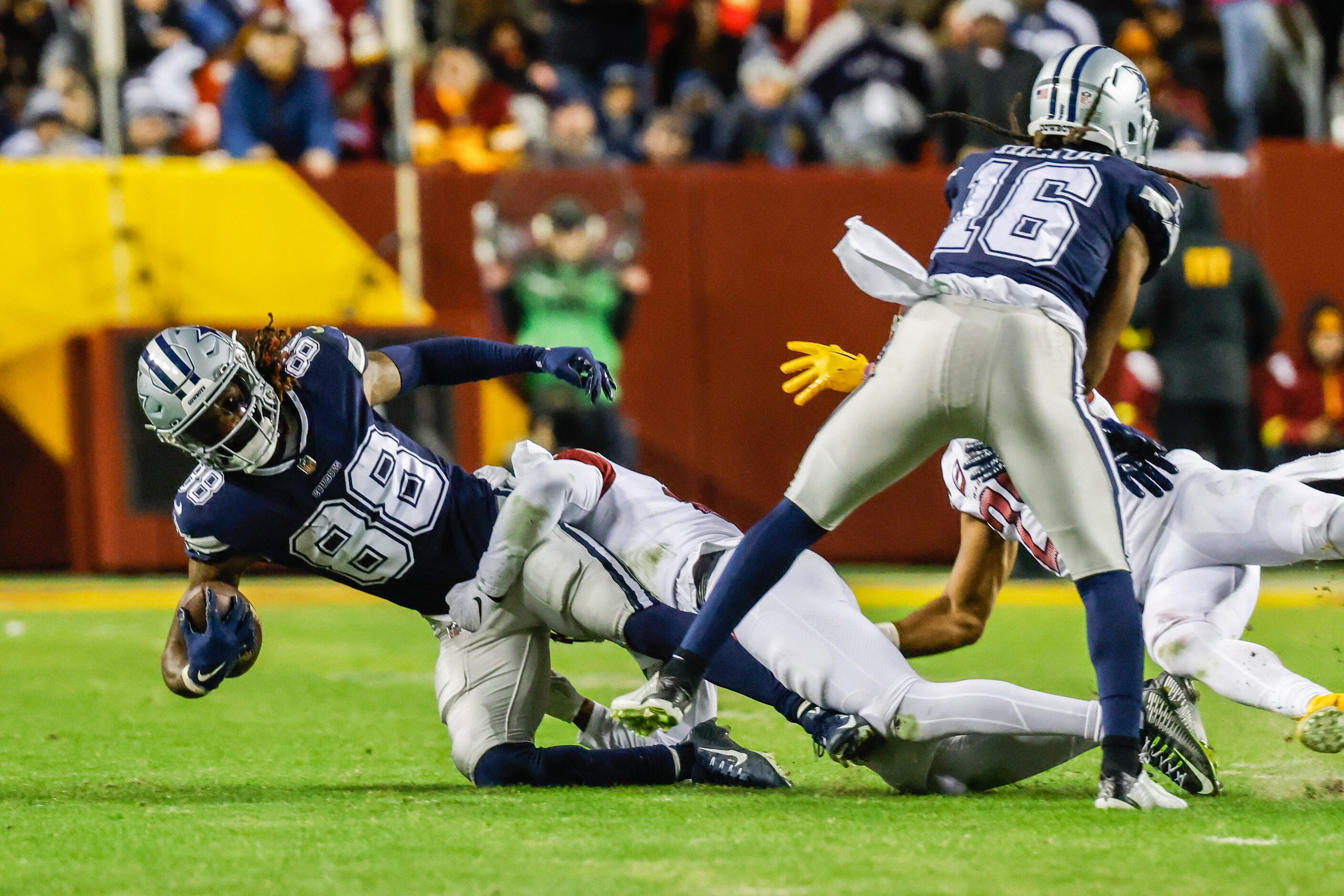 Dallas Cowboys wide receiver CeeDee Lamb (88) gets tackled by Washington Commanders safety...