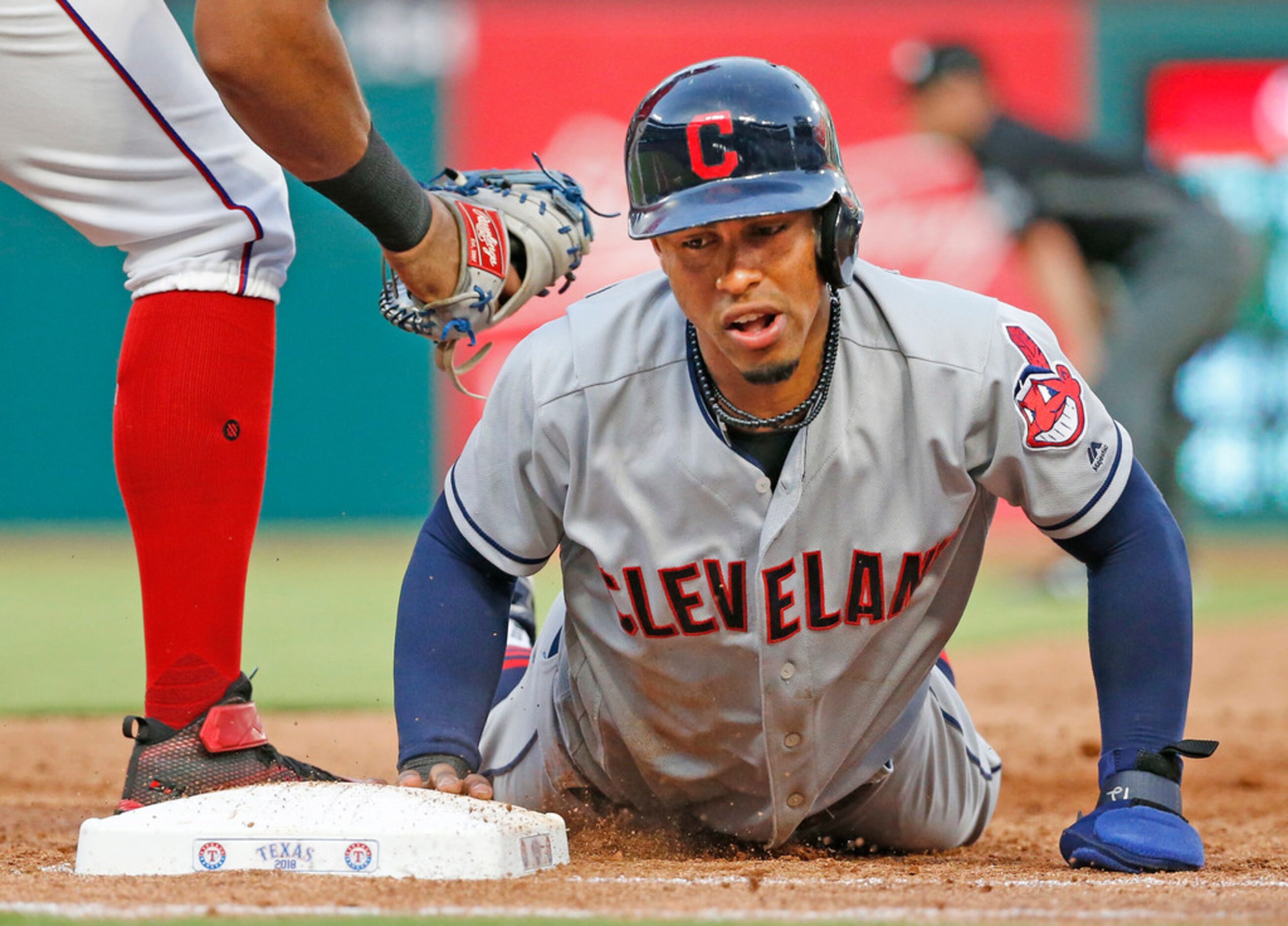 Cleveland Indians shortstop Francisco Lindor (12) dives back to first on a pickoff attempt...