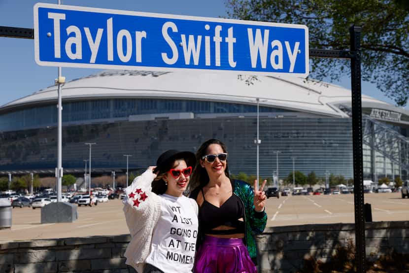 Fans tomándose fotos con un cartel afuera del AT&T Stadium antes del show de Taylor Swift,...