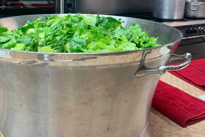 A giant ice bucket is used to prepare Caesar salad for 200 guests at Acton United Methodist...