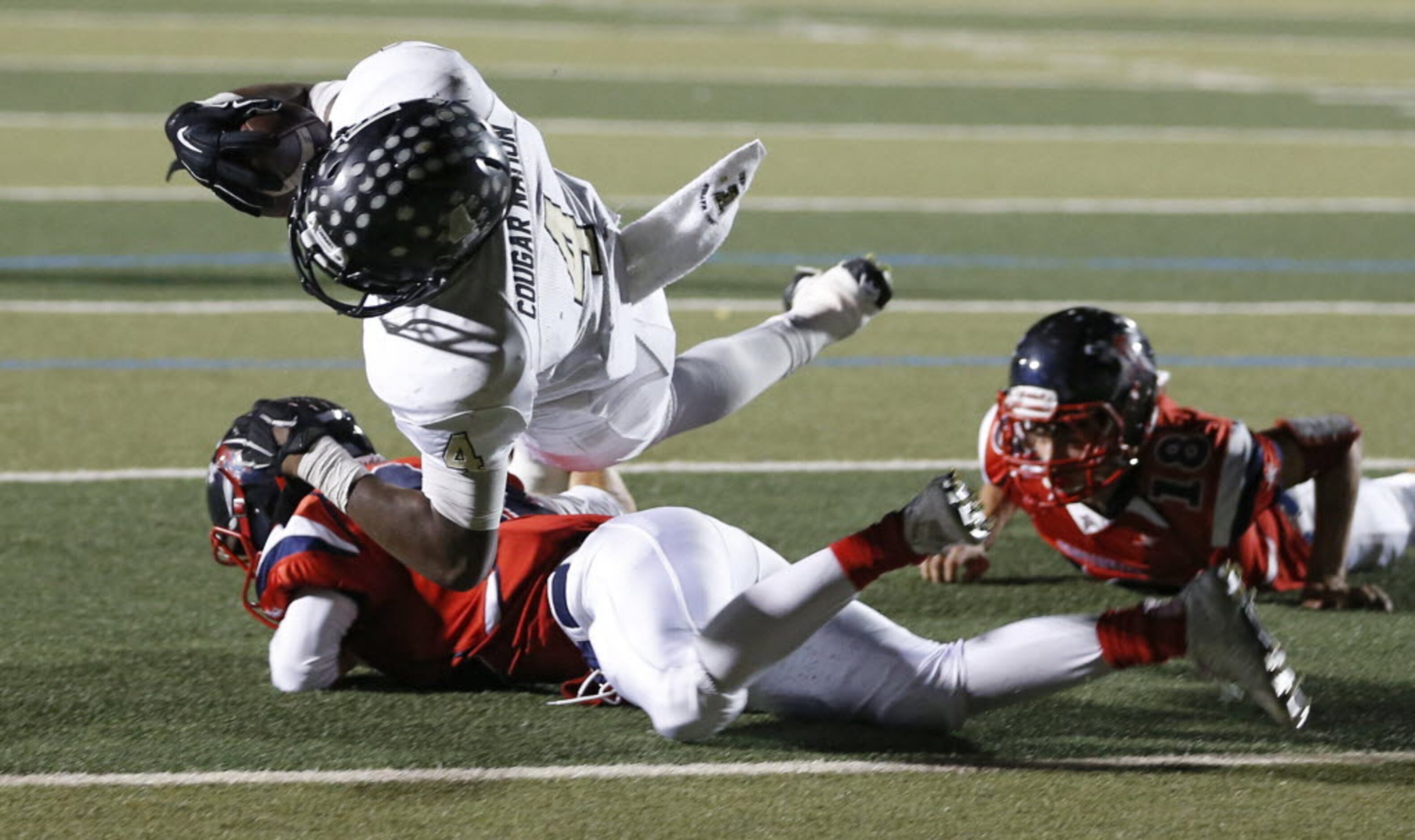 The Colony's Khalil Banks (4) dives over Frisco Centennial's Tanner Laycock (12) for a...