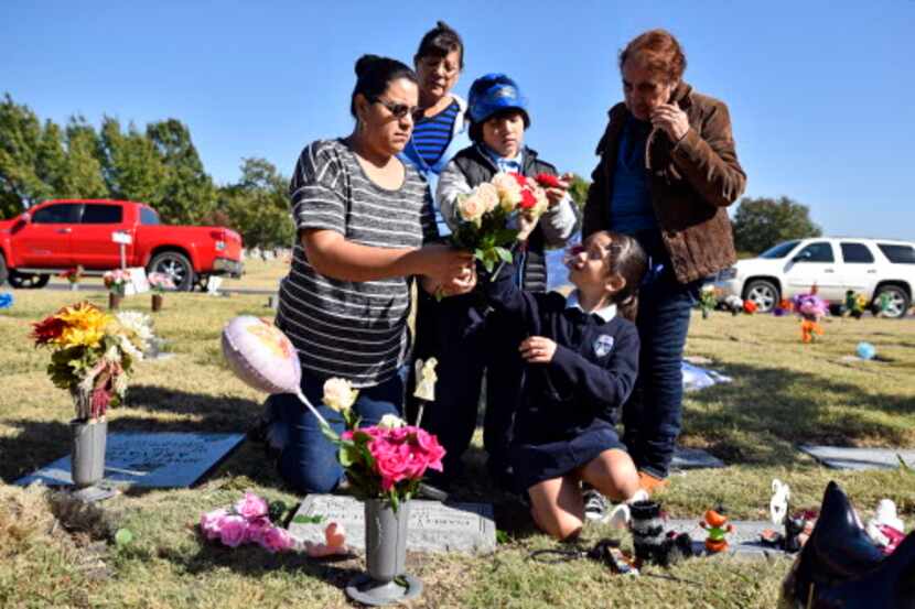 Claudia Alaniz, izq, y sus hijos Carlos y Daisy Escobedo visitan la tumba de una sobrina de...