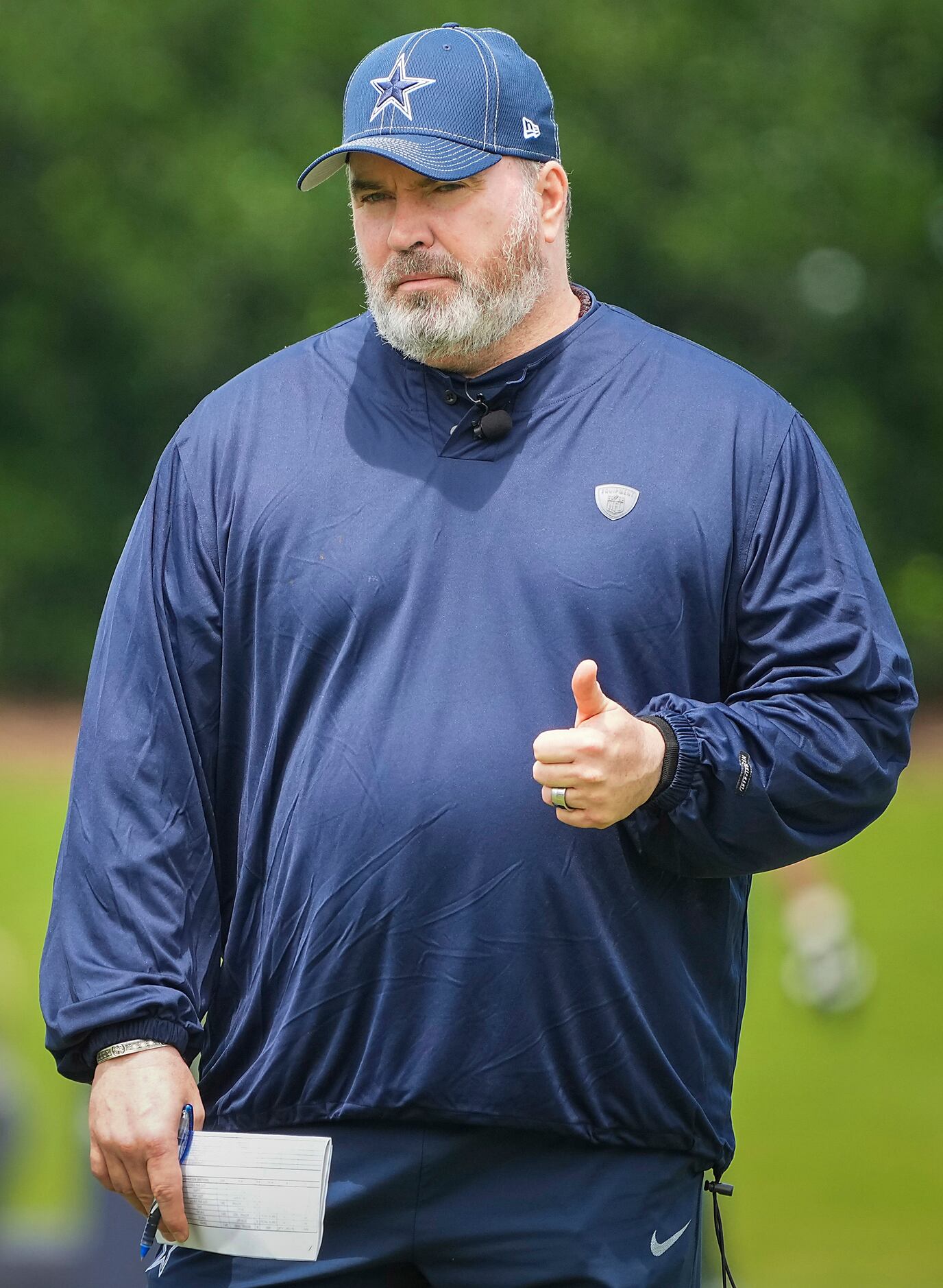 Dallas Cowboys head coach Mike McCarthy gives a thumbs up as he watches his team run drills...