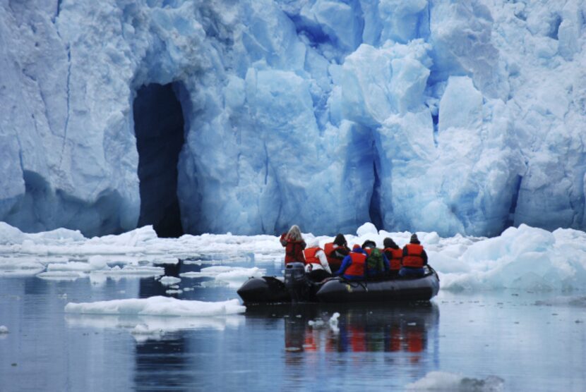 Naturalist Lee Moll (standing) leads a Zodiac group to the face of South Sawyer glacier.