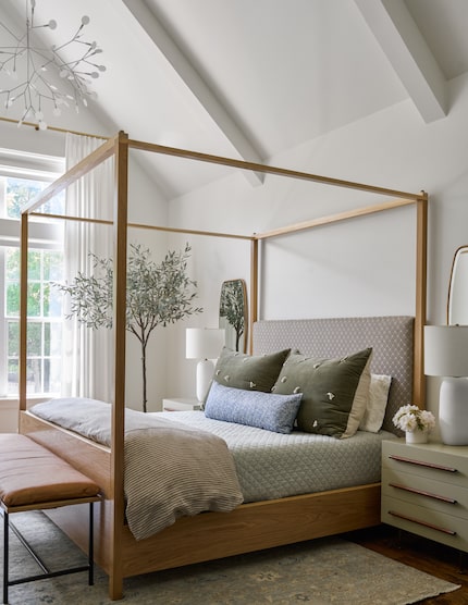 Serene bedroom with white cathedral ceiling, faux olive tree and poster bed