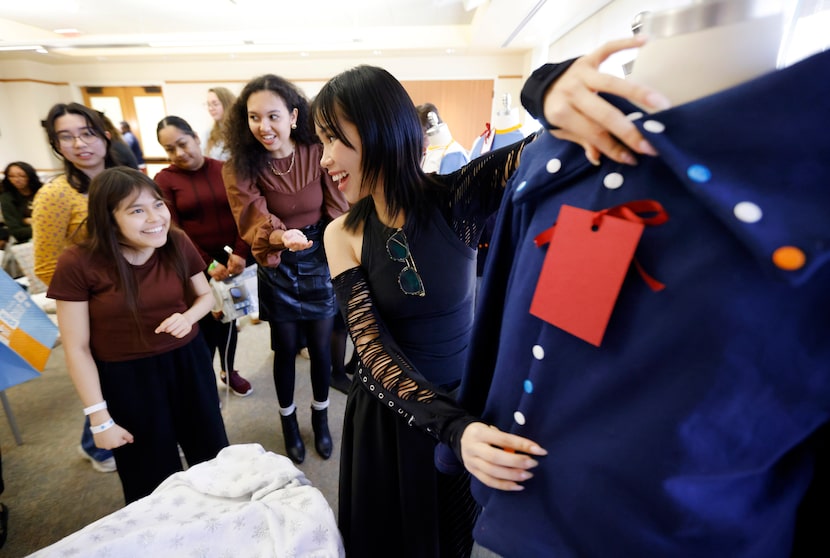 Texas Women’s University fashion design and merchandising junior Kim Ngan (right) shows the...