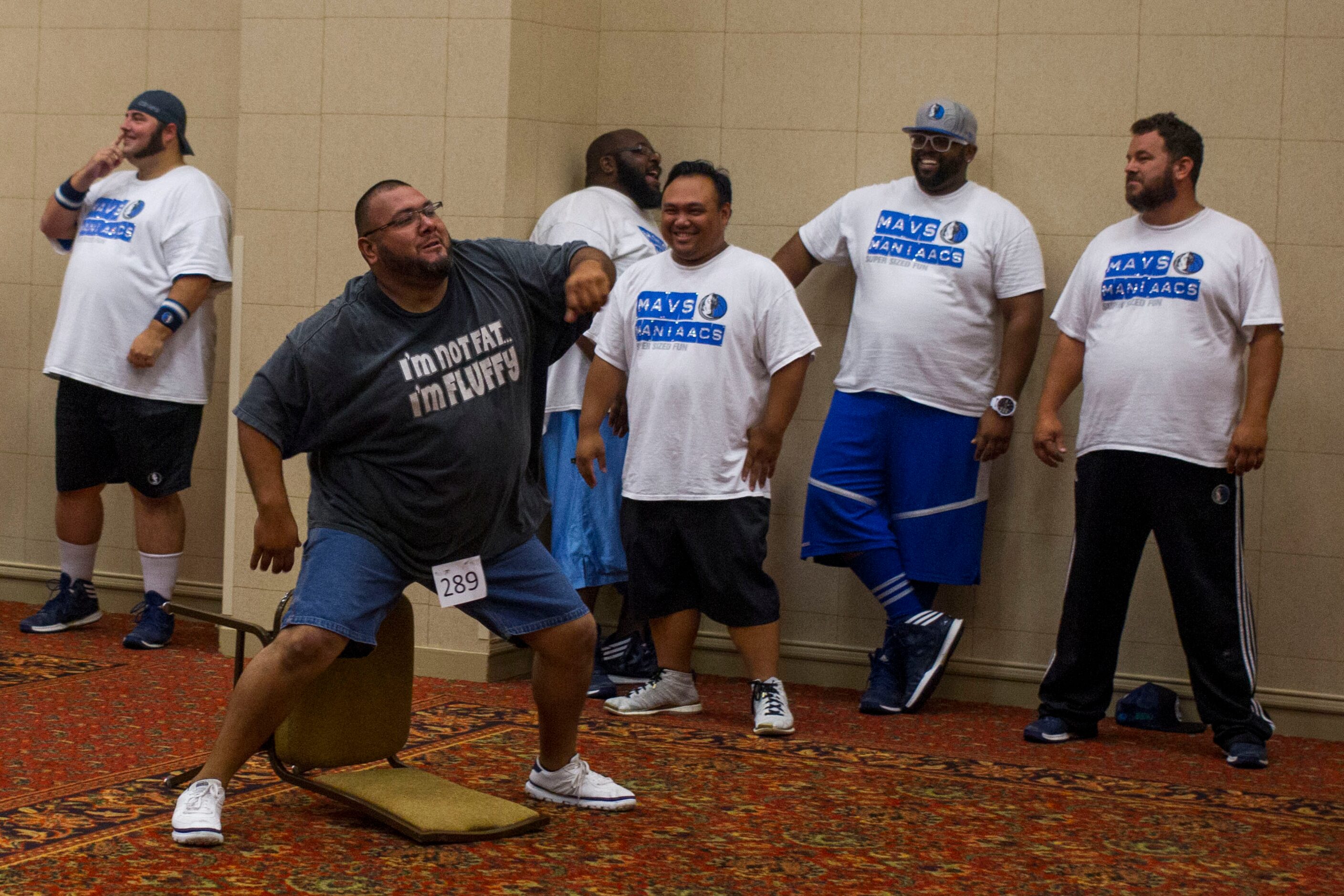 Members of The Mavs ManiAACs, laugh at a contestant's freestyle portion of team tryouts,...