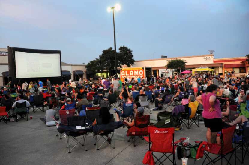 As the sun sets the screen begins to illuminate and attendants prepare for a screening of...
